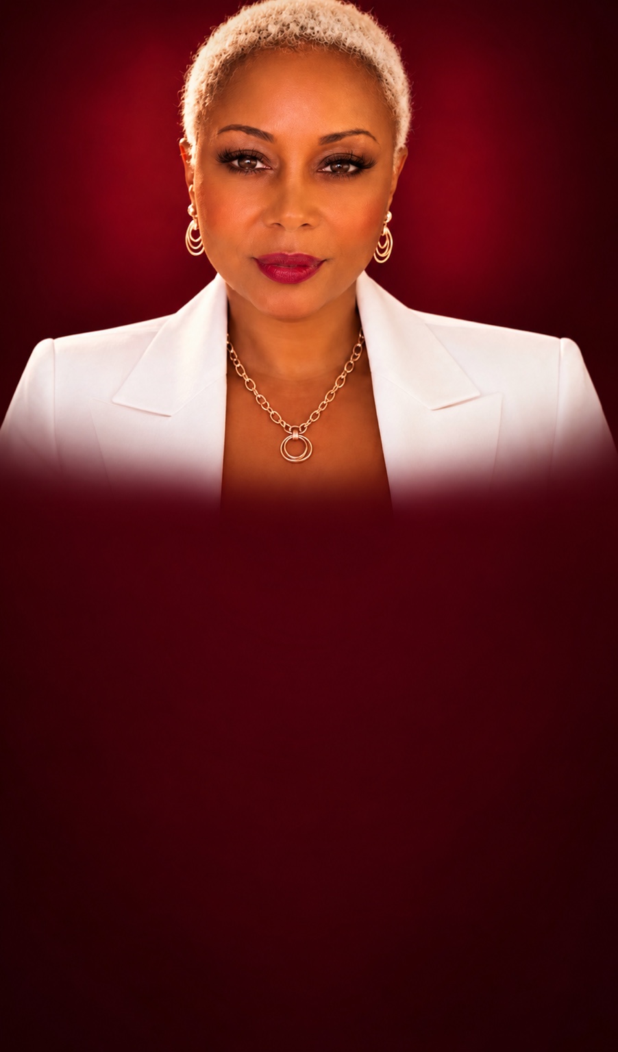Patricia Pollack in a white blazer against a burgundy background